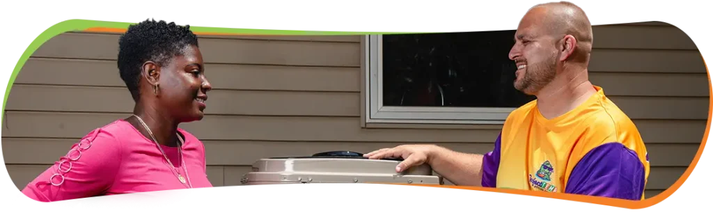 technician and woman standing next to a heat pump