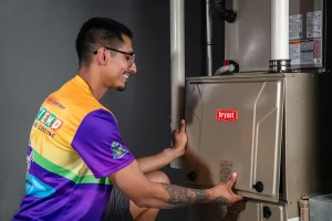 a man in a uniform fixing a furnace